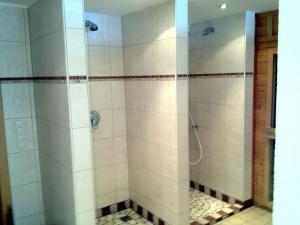 a bathroom with a shower with white tile at Pension Wallnöfer in Mieming