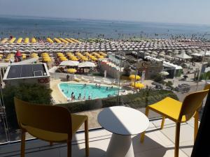 uma vista para um resort com uma piscina e uma praia em App Sea View em Riccione