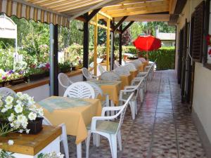 eine Reihe von Tischen und Stühlen auf einer Terrasse in der Unterkunft Erika Villa in Siófok