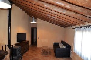 a living room with a couch and a tv at Casa Rural El Cartero in Santa Lecina