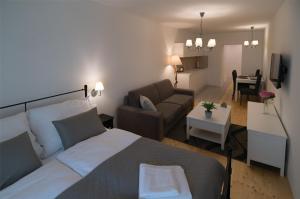 una camera da letto e un soggiorno con un letto e un divano di Wise Owl Apartments a Banská Štiavnica