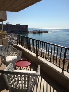 een balkon met stoelen en uitzicht op het strand bij CostaAzul loft, Seaviews frente al mar, Playa los locos in Torrevieja