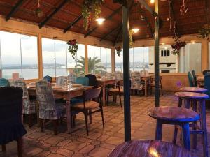 a dining room with tables and chairs and windows at Tyre Boutique Apartments in Soûr