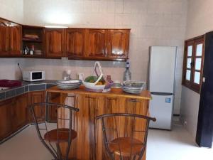 a kitchen with a wooden counter with two chairs at Villa Massilia in Saly Portudal