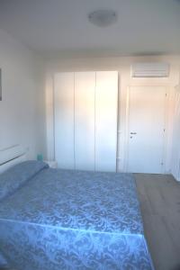 sypialnia z niebieskim łóżkiem i białymi szafkami w obiekcie Via Cipro 16 w Lido di Venezia