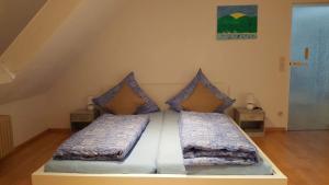 1 cama con 2 almohadas en una habitación en Ferienwohnungen am Naturbad, en Lahr