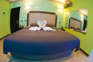 1 dormitorio con 1 cama grande y toallas. en FrioHot Boca Chica, en Boca Chica
