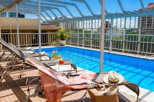 里贝朗普雷托台湾酒店的阳台的游泳池,配有桌椅