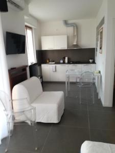 uma sala de estar com um sofá branco e cadeiras em Casa Bonatti em Peschiera del Garda