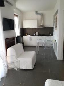 Una sala de estar con un sofá blanco y sillas. en Casa Bonatti, en Peschiera del Garda