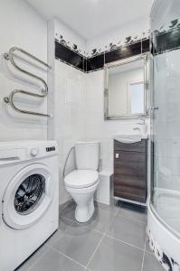een badkamer met een toilet en een wasmachine bij Vanilės apartamentai in Klaipėda