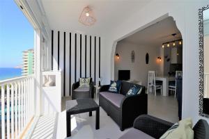 a living room with a couch and chairs and a balcony at Bacana 9-4 in Benidorm