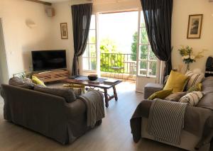 ein Wohnzimmer mit 2 Sofas und einem TV in der Unterkunft Villa Mimosa in Saint-Paul-de-Vence