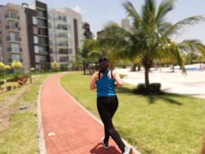 a woman running down a sidewalk near the beach at Casa con alberca y laguna in Veracruz