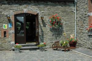 ein Steingebäude mit einer Bank und Blumen darauf in der Unterkunft Hotel Saint-Martin in Bovigny