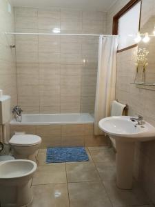 bagno con 2 lavandini, vasca e servizi igienici di Vista Mar Apartamento ad Albufeira