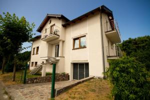 ein weißes Haus mit zwei Balkonen darüber in der Unterkunft Pokoje goscinne "U Adaska" in Chałupy