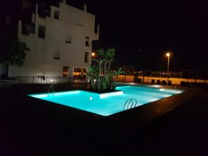 a swimming pool in front of a building at night at Las Terrazas De La Torre Apartment in Roldán
