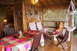 una habitación con mesa y sillas en una cabaña en Villa Rose Caraibes, en Pointe-Noire