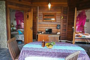 a room with a table and a bedroom with two beds at Villa Rose Caraibes in Pointe-Noire