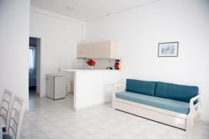 sala de estar con sofá azul y cocina en Samos Apartments, en Marathokampos