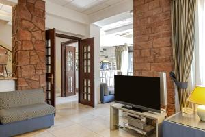 a living room with a television on a table at Hotel Villa Lo Scoglietto in San Vincenzo