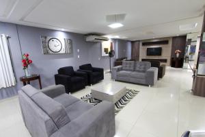 a living room with a couch and chairs and a table at Augusto Palace Hotel in Marabá