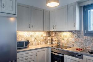 a kitchen with white cabinets and a microwave at Milian Suite in Adamantas