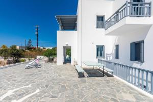 a patio of a white building with two benches at Milian Suite in Adamas