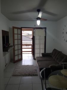 ein Wohnzimmer mit einem Sofa und einem Deckenventilator in der Unterkunft solar norte in Florianópolis