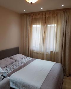 een slaapkamer met een bed en een raam met gordijnen bij Zlatibor lux Kalman in Zlatibor +7 foto's