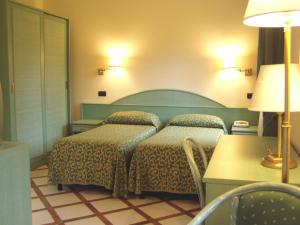 a bedroom with two beds and a table and a lamp at Residence Villaggio Verde in Sorrento