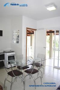 comedor con mesa de cristal y sillas en Pousada do Lima, en Florianópolis