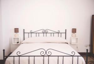 サレルノにあるNei Paraggiのベッドルーム(白いシーツを使用した黒金属製ベッド1台付)
