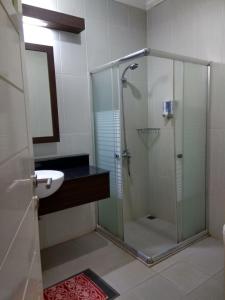 a bathroom with a glass shower and a sink at Puri Ratna Joewita in Batusangkar