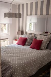 a bedroom with a large bed with red pillows at Apartamento Valtour Valladolid in Valladolid