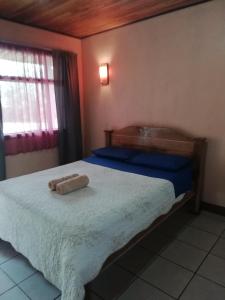 a bedroom with a bed with two towels on it at Cabinas Vista Miravalles in Bijagua