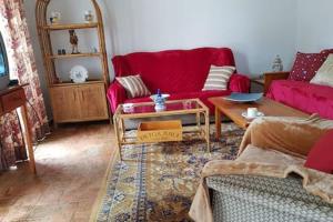 uma sala de estar com um sofá vermelho e uma mesa em Casa rústica no monte das Oliveiras, Sta Margarida, Tavira em Tavira