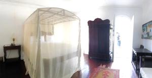 a bedroom with a bed with a white curtain at hotel florita in Jacmel