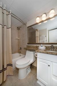 y baño con aseo, lavabo y espejo. en Casa Del Mar Beach View, en Galveston