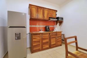 a kitchen with a stove, refrigerator, sink and cabinets at Hotel Casa Pridda in Puerto Escondido