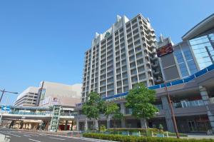 un gran edificio en una calle de la ciudad con árboles en HOTEL VISCHIO AMAGASAKI by GRANVIA, en Amagasaki
