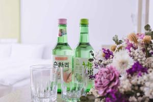 dos botellas de vino y copas en una mesa con flores en Mei Ti Fashion Hotel, en Zhongli