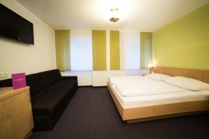 a hotel room with a bed and a couch at Apartments Reiterbäck in Wagrain