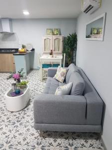 a living room with a gray couch and a kitchen at Casa Anita in Cartagena de Indias +18 photos
