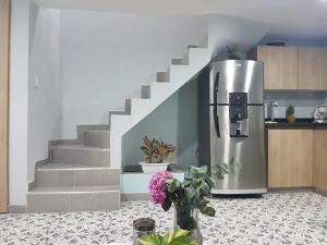 a kitchen with a refrigerator next to a staircase at Casa Anita in Cartagena de Indias