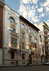 een groot wit gebouw met vlaggen ervoor bij Art Hotel Boston in Turijn