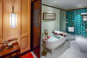 a bathroom with a bath tub and a shower at Little Riverside Hoi An . A Luxury Hotel & Spa in Hoi An