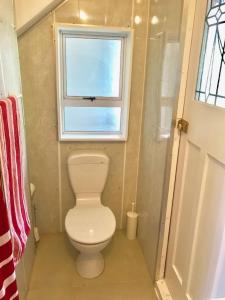uma pequena casa de banho com um WC e uma janela em Cosy studio apartment em Christchurch