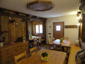 eine Küche und ein Esszimmer mit Holztischen und Stühlen in der Unterkunft B&B Mas di Zonadi in Rabbi
